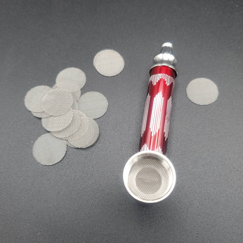 A red smoking pipe with a stainless steel screen inserted in the bowl, with additional screens nearby.