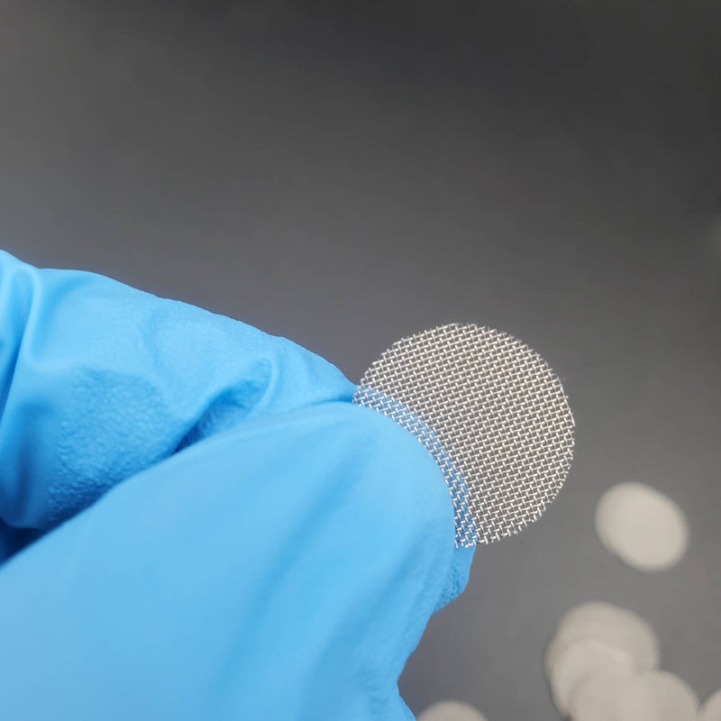 A close-up view of a round stainless steel pipe screen held by a gloved hand, showing the fine mesh details.